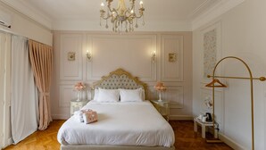 A bedroom with a large bed, a chandelier, a bedside table with a lamp, and a wardrobe. - 14 Gawad Housny (Cairo)