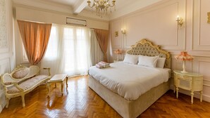 A bedroom with a large bed, a chaise lounge, a small table, and a chandelier. - 14 Gawad Housny (Cairo)