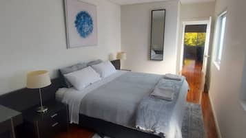 2 habitaciones, escritorio y tabla de planchar con plancha
