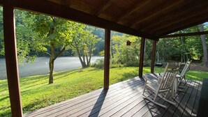 Eine Holzterrasse mit Blick auf einen See und Bäume.