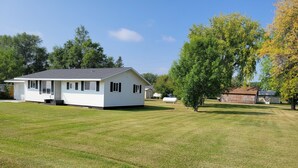 A single-story house with a front porch, a small attached garage, and a well-maintained lawn.