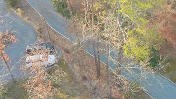 An aerial view of a winding road with a vehicle parked on the side.