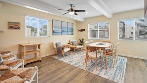 A spacious room with a dining area, a ceiling fan, and large windows with blinds. - Ocean View Perfection - Parking, W/D, Pet Friendly & Steps to Sand (Mission Beach)