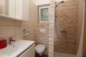 A bathroom with a sink, toilet, and shower.