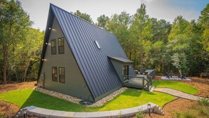 Ein modernes Haus mit Satteldach, einer Terrasse und einem gepflegten Rasen.