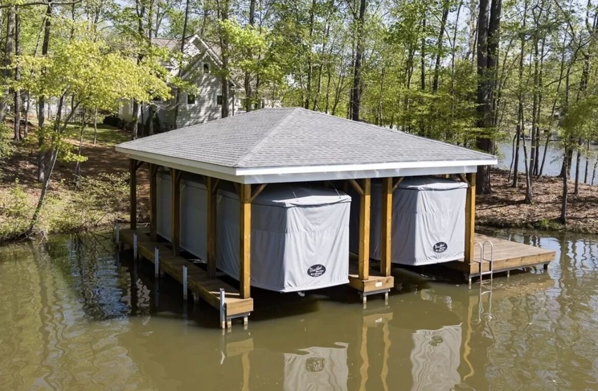Un muelle flotante con zona de estar cubierta, rodeado de agua y árboles.