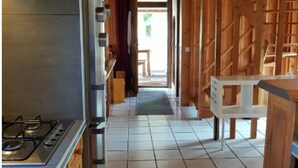 A narrow hallway with a kitchen area on one side, featuring a gas stove and cabinets.