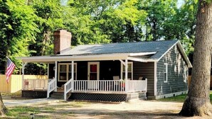 A single-story house with a porch, a chimney, and an American flag. - Beautiful Cottage! 2.5m from I-95,13m to FtBragg (Fayetteville)
