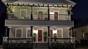 A two-story house with a porch, a red door, and a number 2215 on the front.