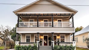 A two-story house with a front porch, a red door, and a number 2215 on the front.