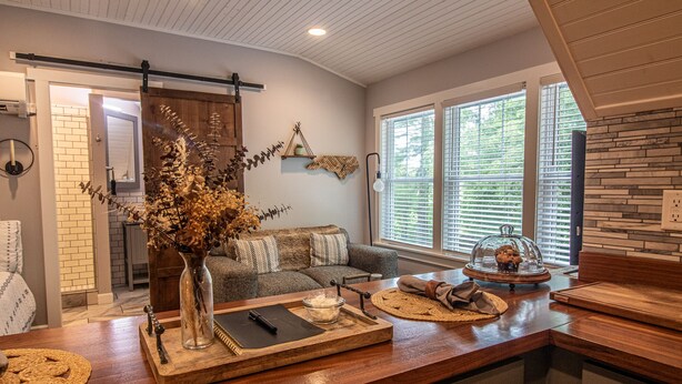 A modern kitchen with a wooden countertop, a vase with dried flowers, and a rustic dining area with a wooden table and chairs. - Quant carriage House, near the city of Asheville and Ashville Airport! (Arden)