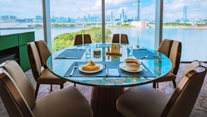 Una mesa redonda con vistas a un horizonte urbano y un río.