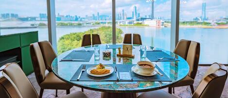 A round table with a view of a city skyline and a river.