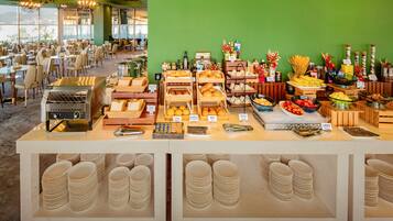 A buffet setup with various food items and a grill station.