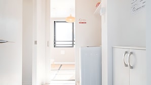 Una cocina moderna y minimalista con armarios blancos, horno empotrado y refrigerador.