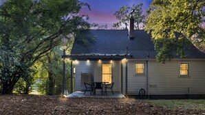 A house with a porch, a table with chairs, and a view of the sky.