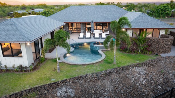 Une maison moderne dotée d’une piscine, d’un patio couvert et offrant une vue sur l’océan.