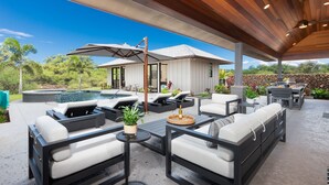 Une terrasse extérieure avec des sièges, une piscine et un espace abrité offrant une vue sur le paysage.
