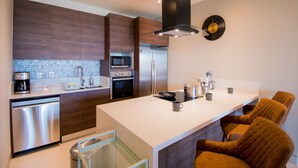 Una cocina moderna con una isla central, electrodomésticos de acero inoxidable y armarios de madera.