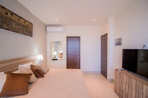 A hotel room with a bed, a TV, a wardrobe, and a door.
