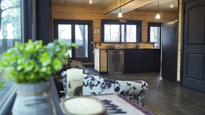 A modern kitchen with wooden walls, a built-in oven, and a refrigerator.