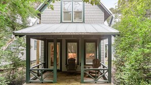 A house with a porch, wooden railings, and a window with blinds. - Sundays at the Millers - BOTH CLUBS (Bald Head Island)