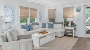 A modern living room with a white sofa, a coffee table, and a side table with a lamp. - Sundays at the Millers - BOTH CLUBS (Bald Head Island)
