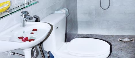 Un baño moderno con lavamanos, inodoro y ducha blancos.