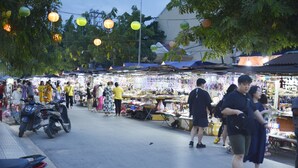 A bustling outdoor market with various stalls and people shopping. - Lisa Homestay 2 (Da Nang)