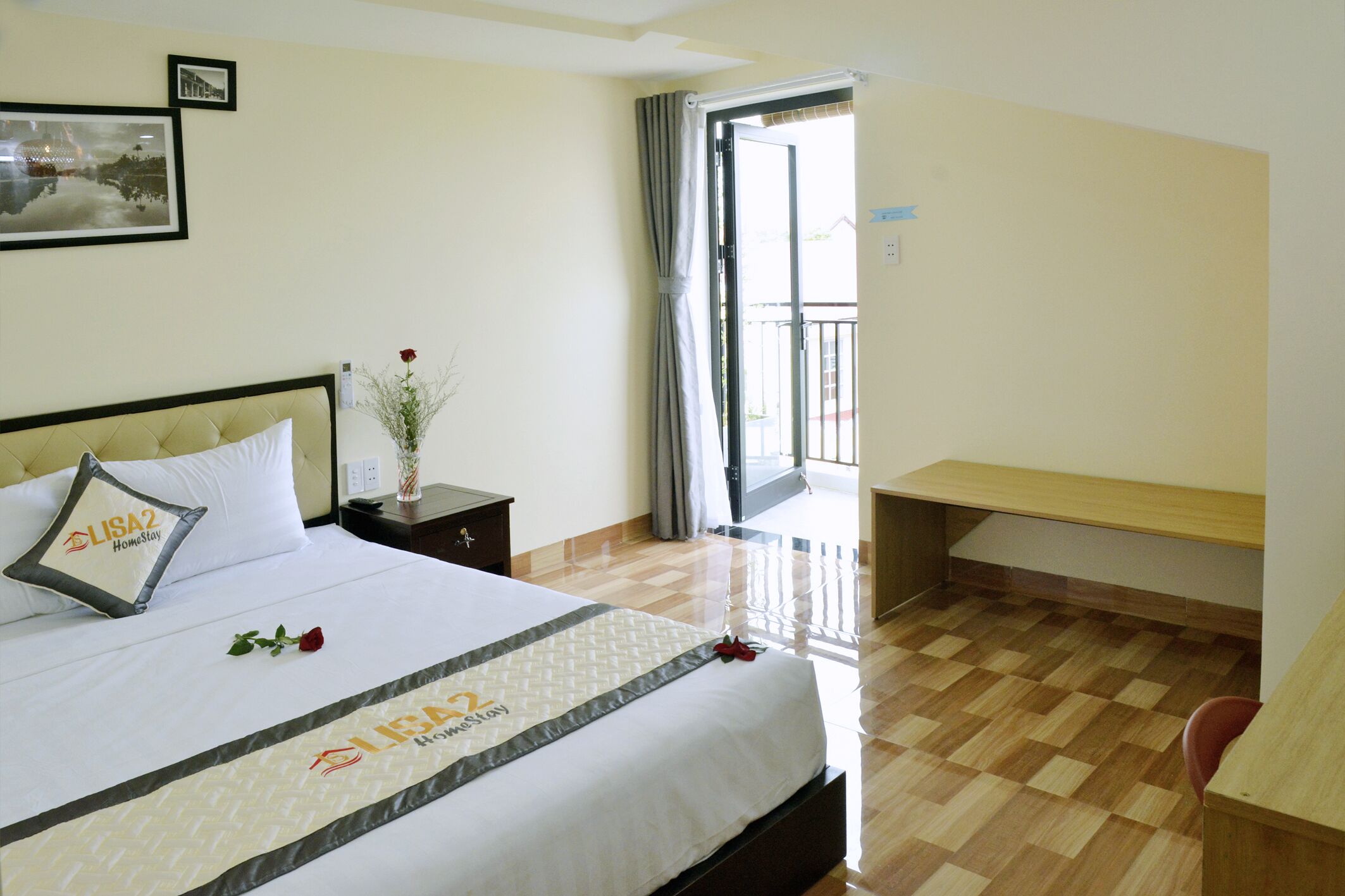 Une chambre d’hôtel avec un lit, une table de chevet, un bureau et un balcon.
