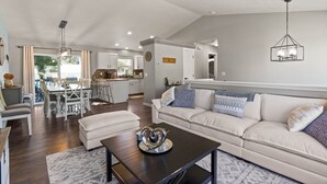 A spacious living room with a sofa, coffee table, and dining area.
