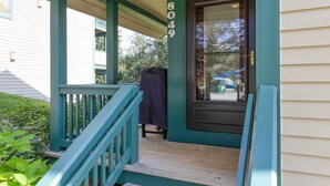 A wooden porch with teal railings and a black door. - Seven Springs 2BR Loft Premium Condo, sleeps 11! by RedAwning (Champion)