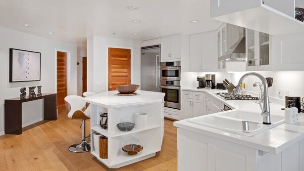 A modern kitchen with white cabinetry, stainless steel appliances, and a central island with a bowl. - Ice House 317 2 Bedroom Condo by RedAwning (Telluride)