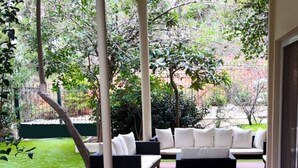 Un espace avec un bain à remous, des sièges extérieurs et une vue sur un jardin.
