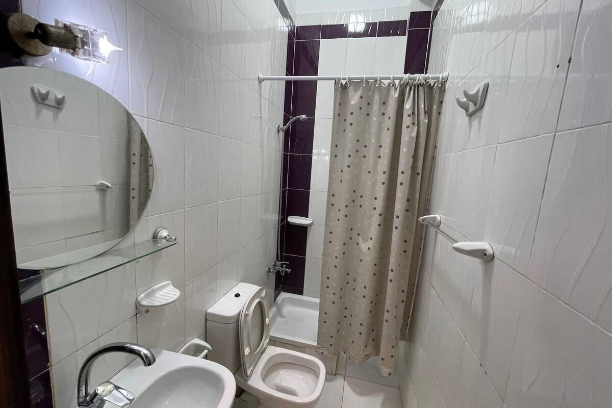 Une salle de bain compacte comprenant un lavabo, des toilettes, un bidet et un espace douche.