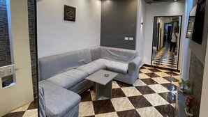 A modern hotel lobby with a checkered floor, a grey sectional sofa, and a small table. - Family Palace Downtown Cairo  (Cairo)