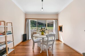 A room with a dining table, chairs, a bookshelf, and a large window with curtains. - Highfields - Valley Views - Bathurst Acreage (Robin Hill)