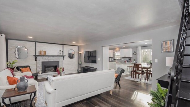 A spacious living room with a fireplace, a dining area, and a kitchen visible through an open doorway. - Champion Center Accommodations - 6 beds, 2 bath (Appleton)