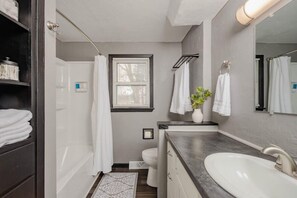 Bathtub, hair dryer, towels, shampoo
