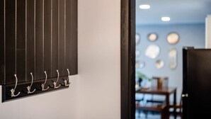 A hallway with a black vertical panel and a row of silver hooks on the wall. - Champion Center Accommodations - 6 beds, 2 bath (Appleton)