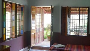 Una habitación con cama, escritorio y ventana con vistas al exterior.