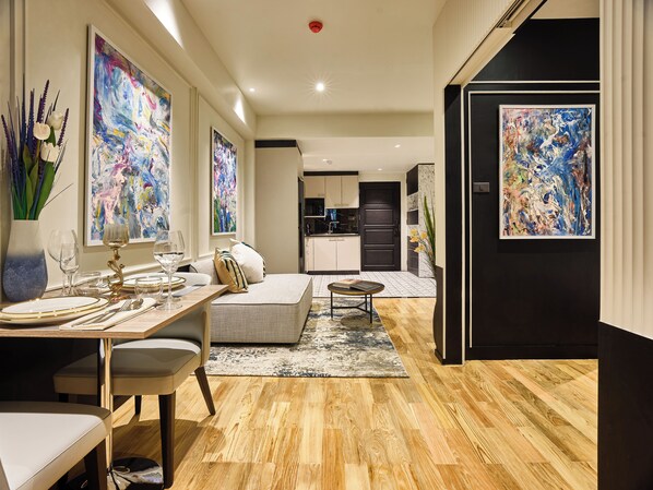 A modern interior with a dining area, sofa, and kitchen. - Floral Court Hotel & Residence Sukhumvit 13 (Bangkok)