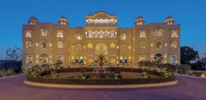 A large, ornate building with multiple arches and a central fountain.