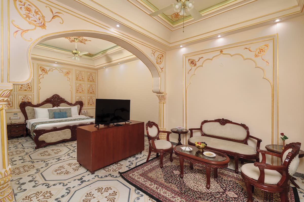 A room with a bed, a TV, a desk, a sofa, and a coffee table.