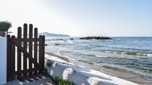 Eine Küstenlandschaft mit einem hölzernen Tor, Strand und Meer.