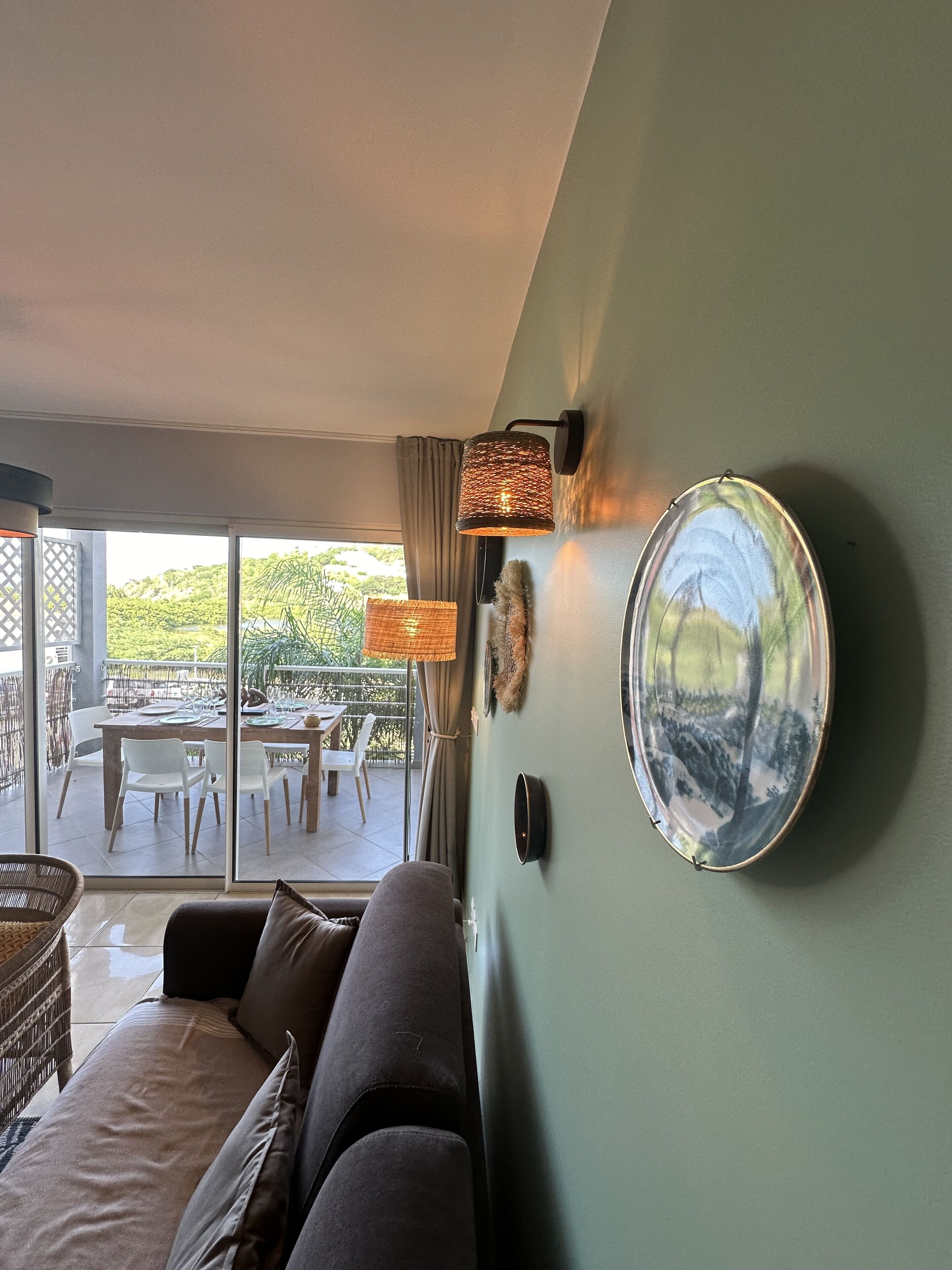 Una sala moderna con un sofá, una mesa de comedor con sillas y un ventanal con vistas al exterior.