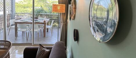Una sala moderna con un sofá, una mesa de comedor con sillas y un ventanal con vistas al exterior.