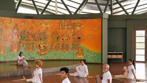 Ein Yogastudio mit hoher Decke und Wandgemälde.