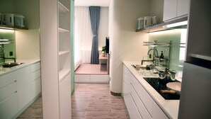 Moderni keittiö, jossa on keskeinen saareke, integroidut kodinkoneet ja näkymä ruokailutilaan.