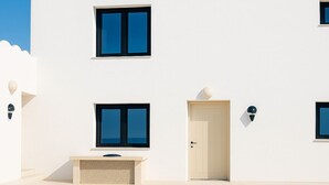 A modern white building with a pool, featuring large windows and a door. - Junior Villa for up to 10 vacationers full view (Piskopiano)